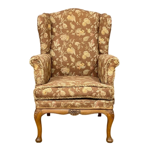 355 - A vintage wingback armchair.