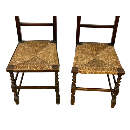 95 - A pair of 1920’s oak side chairs on rush seats.