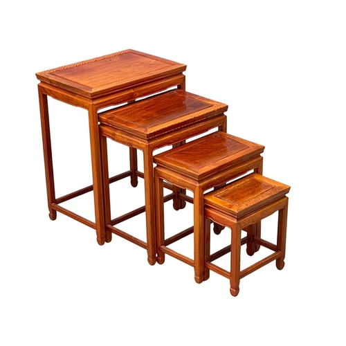 951 - A tall Chinese teak nest of tables.