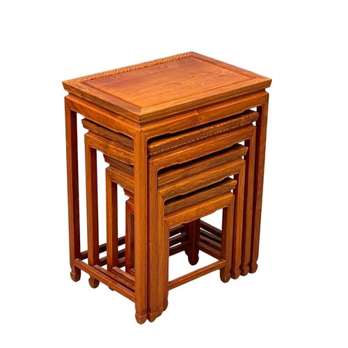 951 - A tall Chinese teak nest of tables.