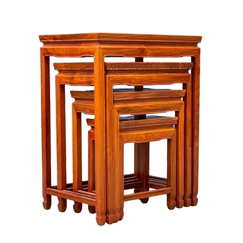 951 - A tall Chinese teak nest of tables.