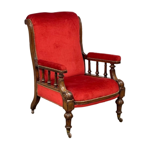 953 - A large Victorian oak framed gents armchair on brass cup casters. Circa 1870.