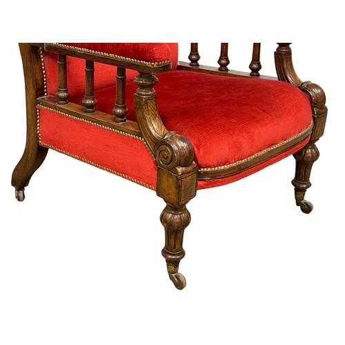 953 - A large Victorian oak framed gents armchair on brass cup casters. Circa 1870.