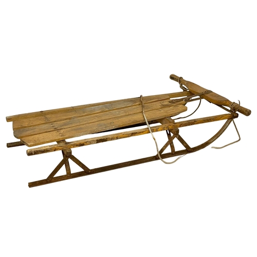 120A - An early 20th century wooden sleigh. 104cm