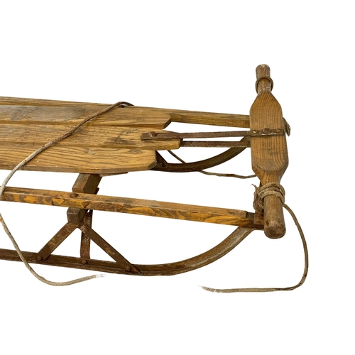 120A - An early 20th century wooden sleigh. 104cm