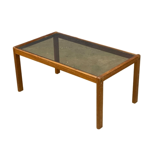 270J - A Mid Century teak coffee table with smoked glass top. 86x49x40cm