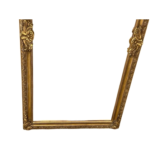 949 - A very large ornate gilt framed bevelled mirror. 99.5x212cm