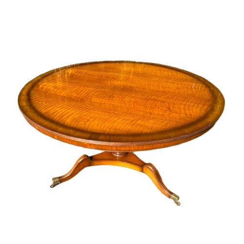 1110 - A large Regency style mahogany pedestal centre table on brass cup casters