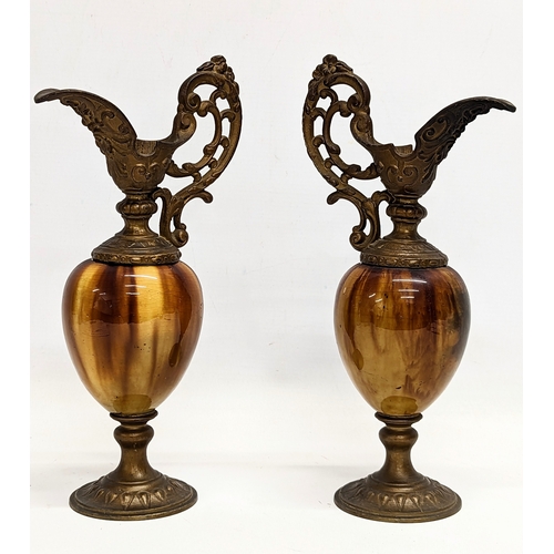 400 - A pair of ornate early 20th century brass and onyx ornamental ewers. 28cm