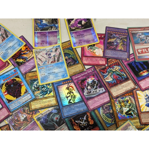 332 - A collection of Pokémon and Yu-Gi-Oh! game cards, in Pokémon tin.