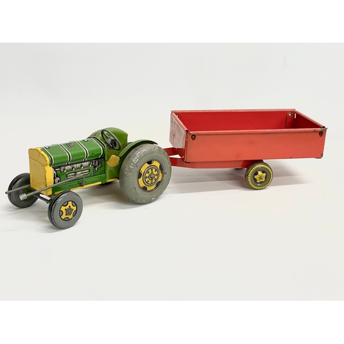 71 - A vintage Mettoy Playthings tinplate tractor and trailer. Total length 46cm