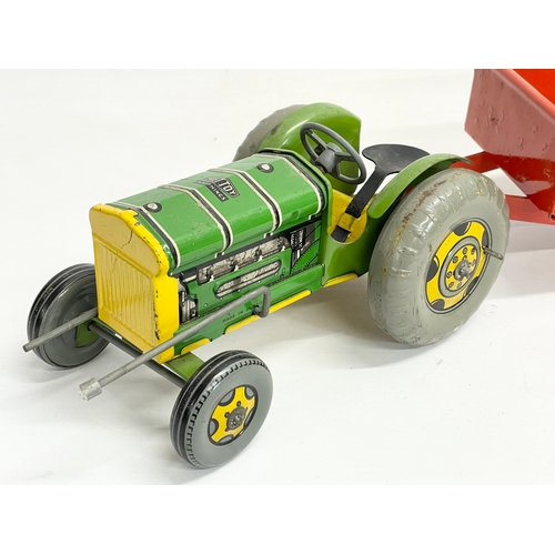 71 - A vintage Mettoy Playthings tinplate tractor and trailer. Total length 46cm