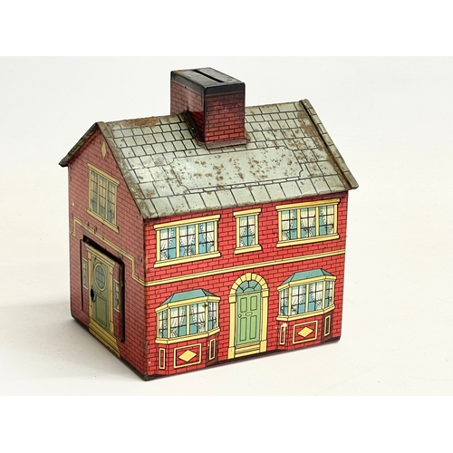 90 - An early 20th century tin plate money box house. 12x14cm