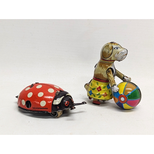 111 - A vintage West German wind up tin ladybird toy, with other German tin toy.
