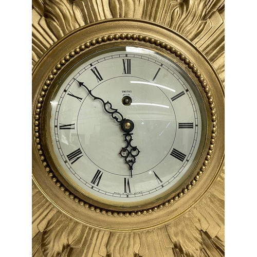 270 - A large vintage Smiths Sunburst clock with key. Smiths 8 Day Floating Balance. 66x48cm