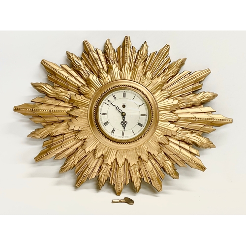 270 - A large vintage Smiths Sunburst clock with key. Smiths 8 Day Floating Balance. 66x48cm