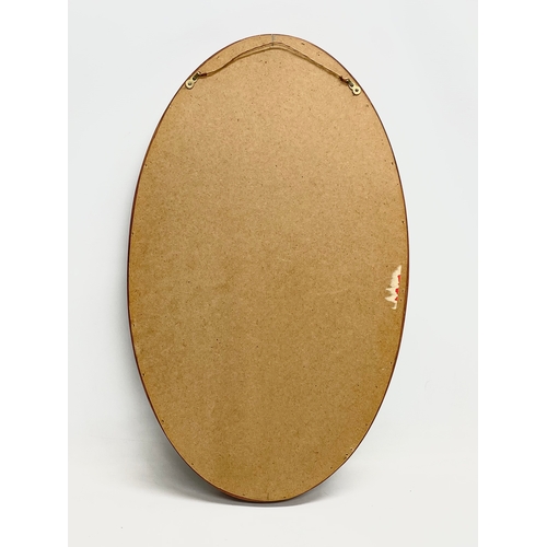 275 - A G-Plan Mid Century teak framed oval mirror. 43x71cm