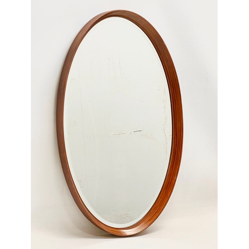 275 - A G-Plan Mid Century teak framed oval mirror. 43x71cm