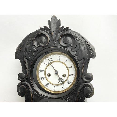 296 - A late 19th century oak wall clock with pendulum. 29x69cm