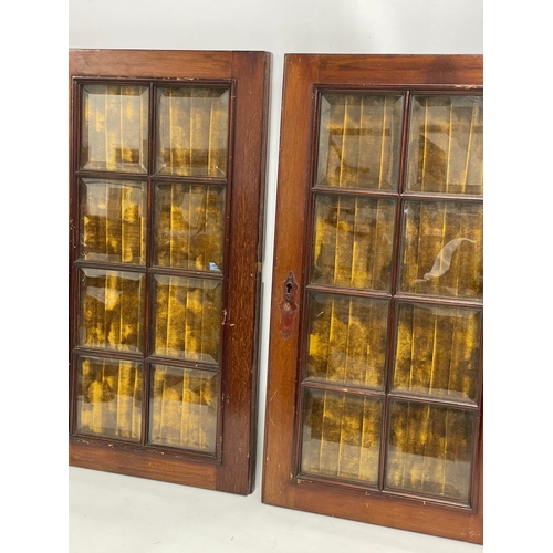 306 - A pair of Victorian mahogany cabinet doors with bevelled glass panels. 31x58cm