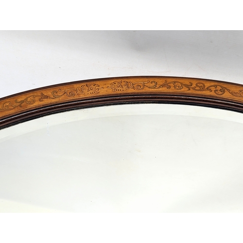195G - An Edwardian inlaid mahogany bevelled mirror. 71x50.5cm