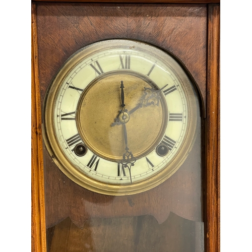 196D - A Victorian Walnut wall clock with pendulum. 70cm