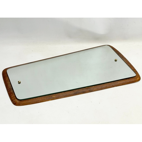 196I - A Mid Century teak framed mirror. 34x65cm