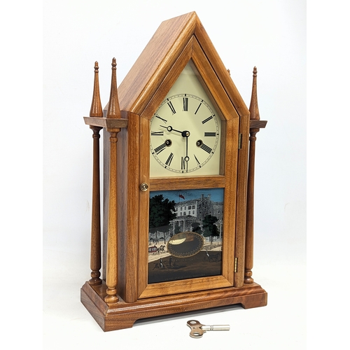 207C - A vintage neogothic style mantle clock, with key and pendulum. 29.5x48.5cm