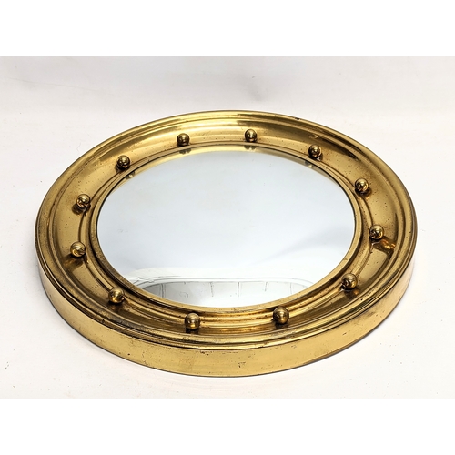 196P - A vintage brass convex mirror. 42.5cm