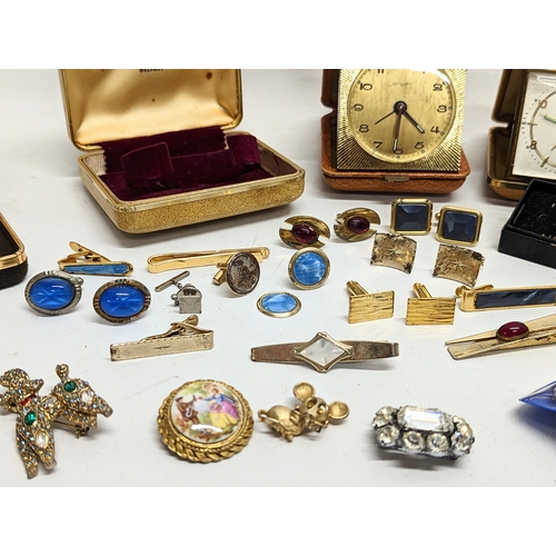 591Y - A sundry lot including vintage cufflinks, 2 vintage travel clocks by Jerger and Estyma, and brooches... 