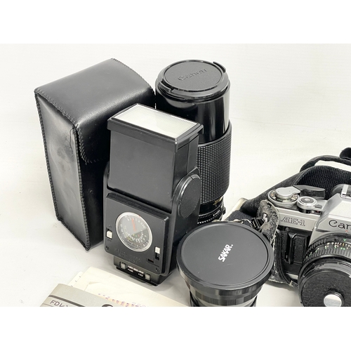 376A - A vintage Canon AE-1 camera with accessories.