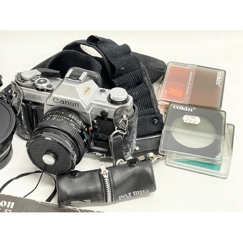 376A - A vintage Canon AE-1 camera with accessories.