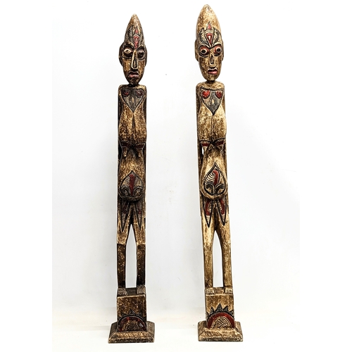 714 - A pair of tall African style wooden figures. 100cm