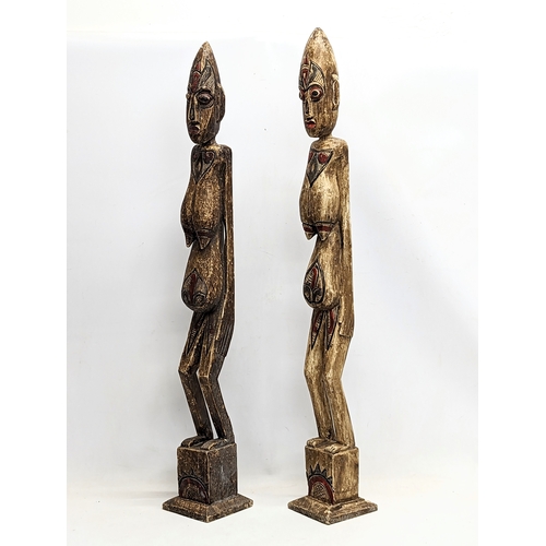 714 - A pair of tall African style wooden figures. 100cm