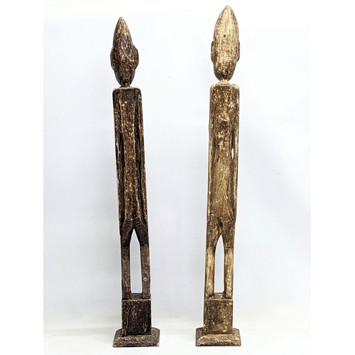 714 - A pair of tall African style wooden figures. 100cm