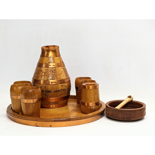 715 - A vintage oak and copper bound drinking set including goblets, jug and tray. Engraved in Latin 