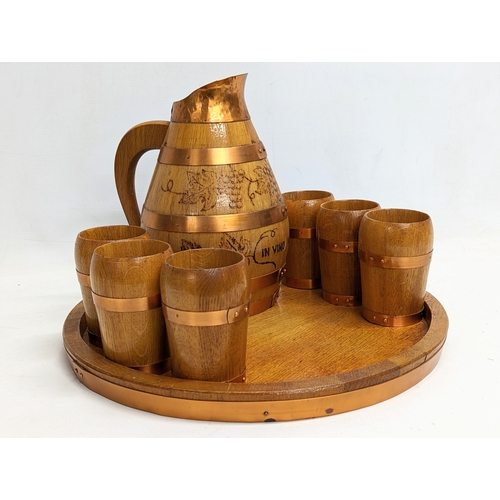 715 - A vintage oak and copper bound drinking set including goblets, jug and tray. Engraved in Latin 