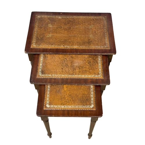 207 - A mahogany nest of tables with leather tops.