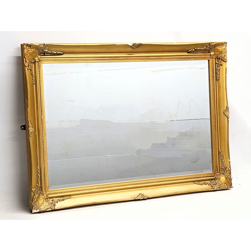 379S - An ornate gilt framed bevelled mirror. 90x64.5cm