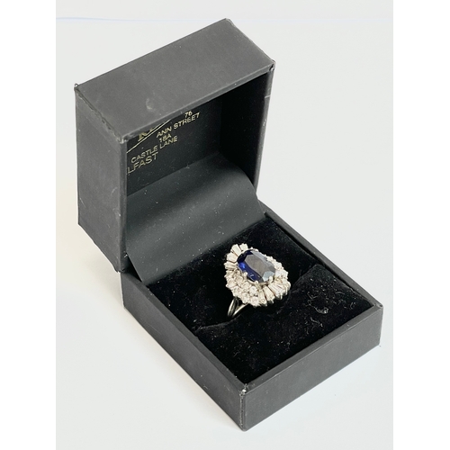 598B - An excellent quality 18ct gold sapphire and diamond cluster ring. Central oval cut sapphire calculat... 