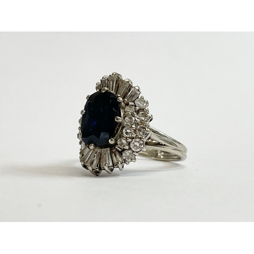 598B - An excellent quality 18ct gold sapphire and diamond cluster ring. Central oval cut sapphire calculat... 