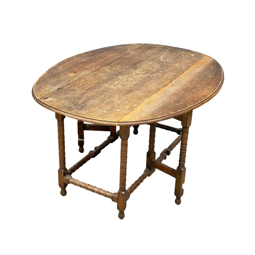 195K - A large early 20th century oak drop leaf table. Open 136x104x72cm. Closed 51cm