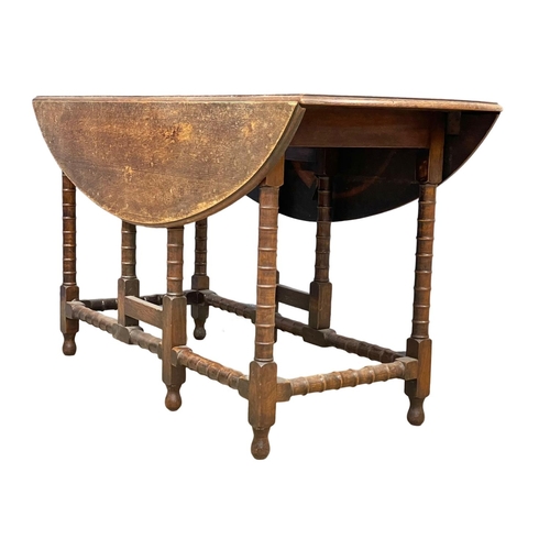 195K - A large early 20th century oak drop leaf table. Open 136x104x72cm. Closed 51cm