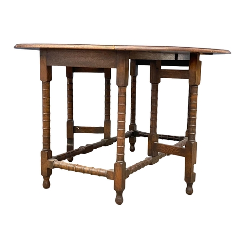 195K - A large early 20th century oak drop leaf table. Open 136x104x72cm. Closed 51cm