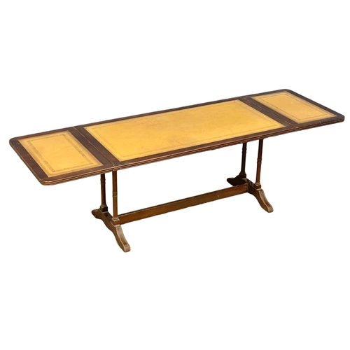 247 - A mahogany drop leaf coffee table with leather top. Open 141x44x42cm