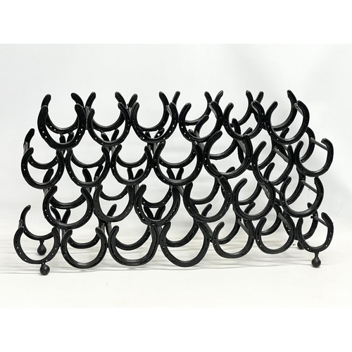 280E - A large horse shoe wine rack. 99x20x53cm