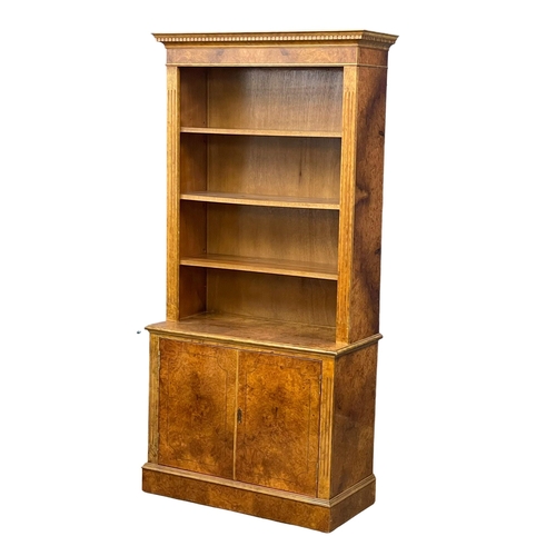 1079 - A Burr Walnut bookcase. 87x40x183cm