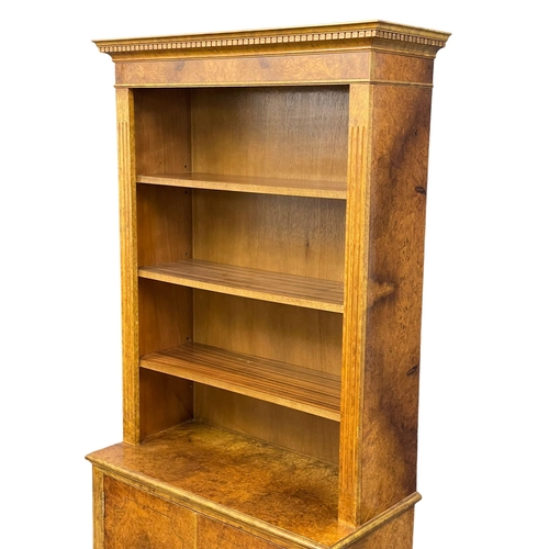 1079 - A Burr Walnut bookcase. 87x40x183cm