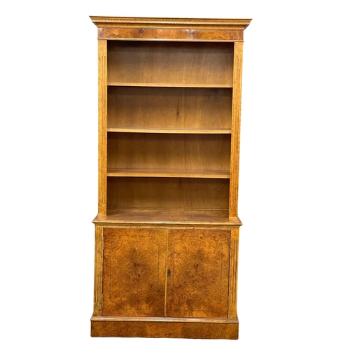 1079 - A Burr Walnut bookcase. 87x40x183cm