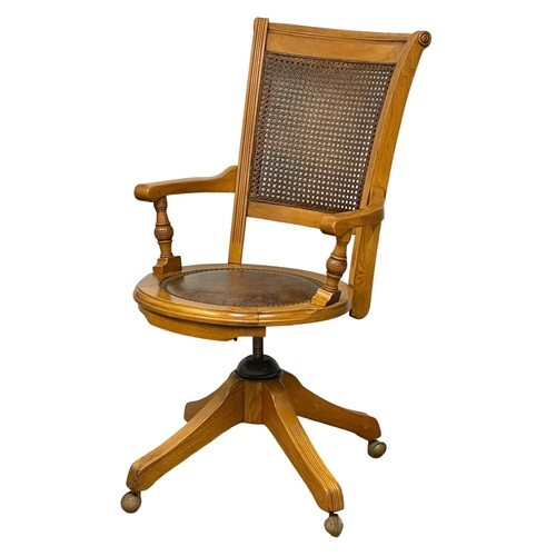 1090 - A good quality modern oak swivel desk chair, with leather seat and bergere back